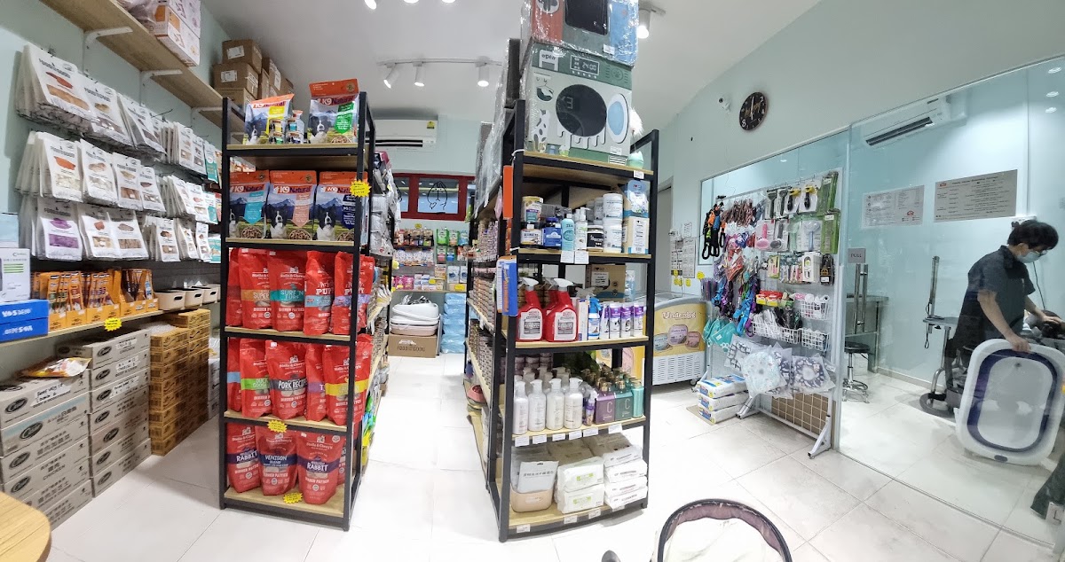 Inside Pawdy House: retail aisles, with the grooming room visible behind a glass wall on the right